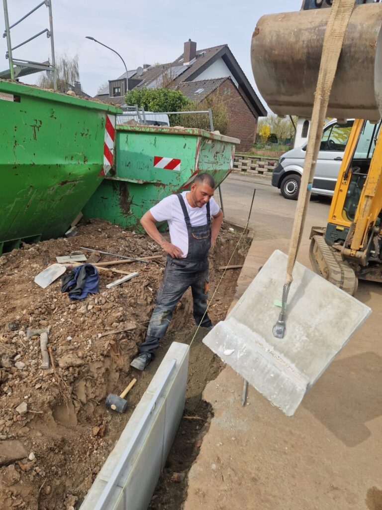 Betonelement wird mit dem Bagger gesetzt