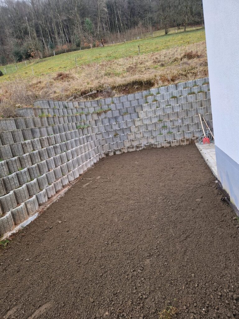 Vorher: Erdfläche an der Stützmauer