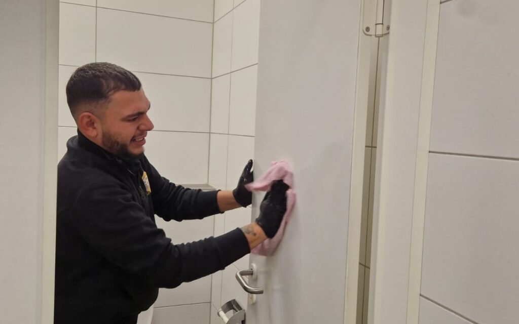 Mitarbeiter von Yulian Bau bei der Reinigung einer Sanitärkabine